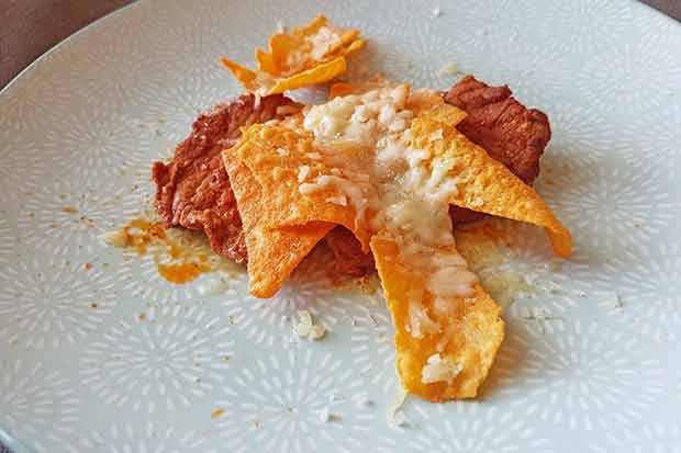 Baked escalope with tortilla chips.
